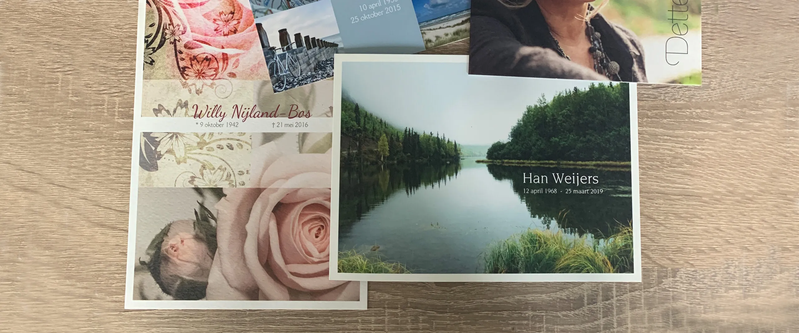 Verschillende rouwkaarten naast elkaar op een houten tafel