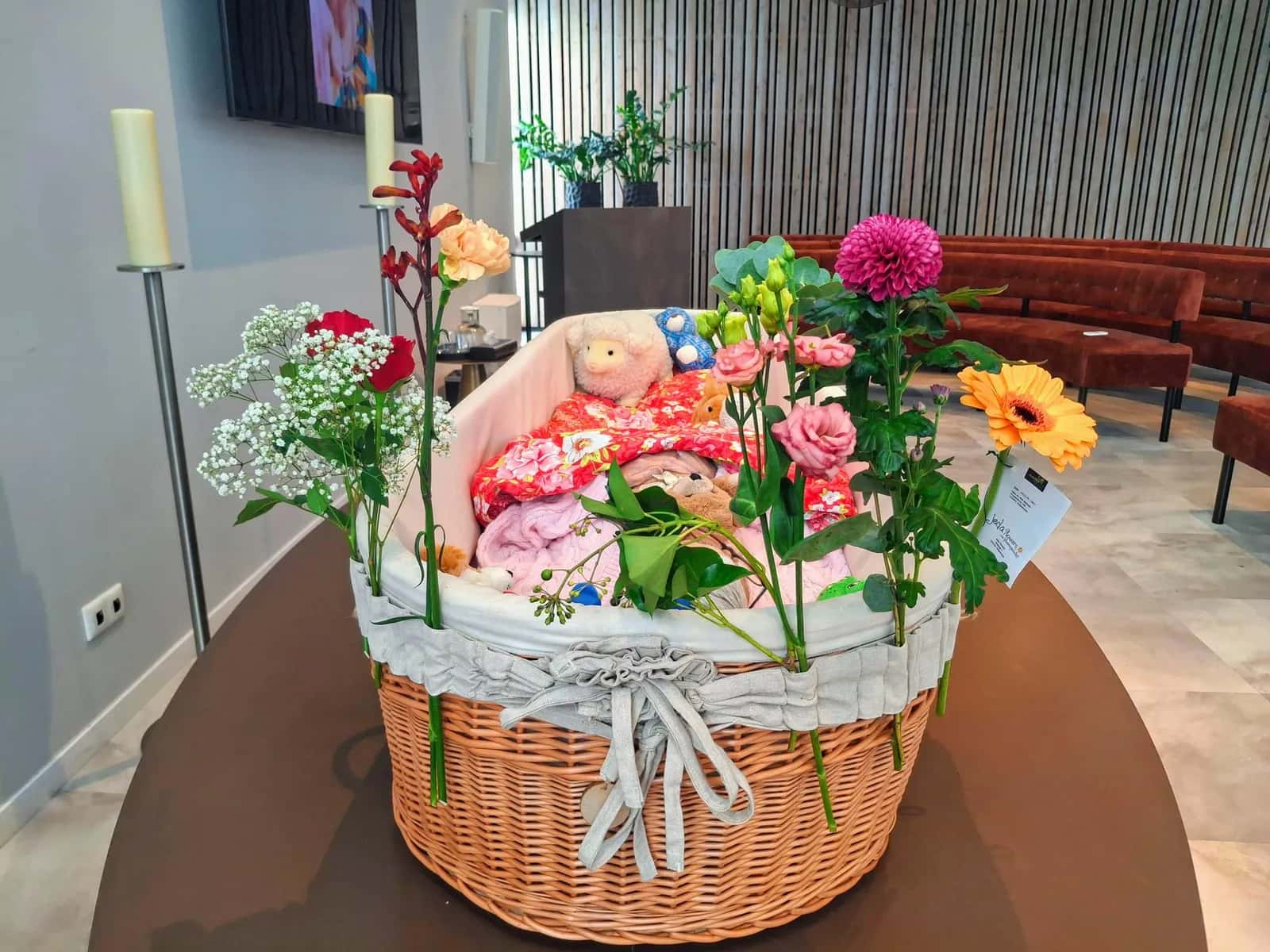 Rieten mand vol bloemen, met kaarsen ernaast