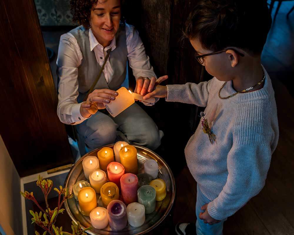 Kaarsen Annemarie steekt samen met een kind kaarsen aan